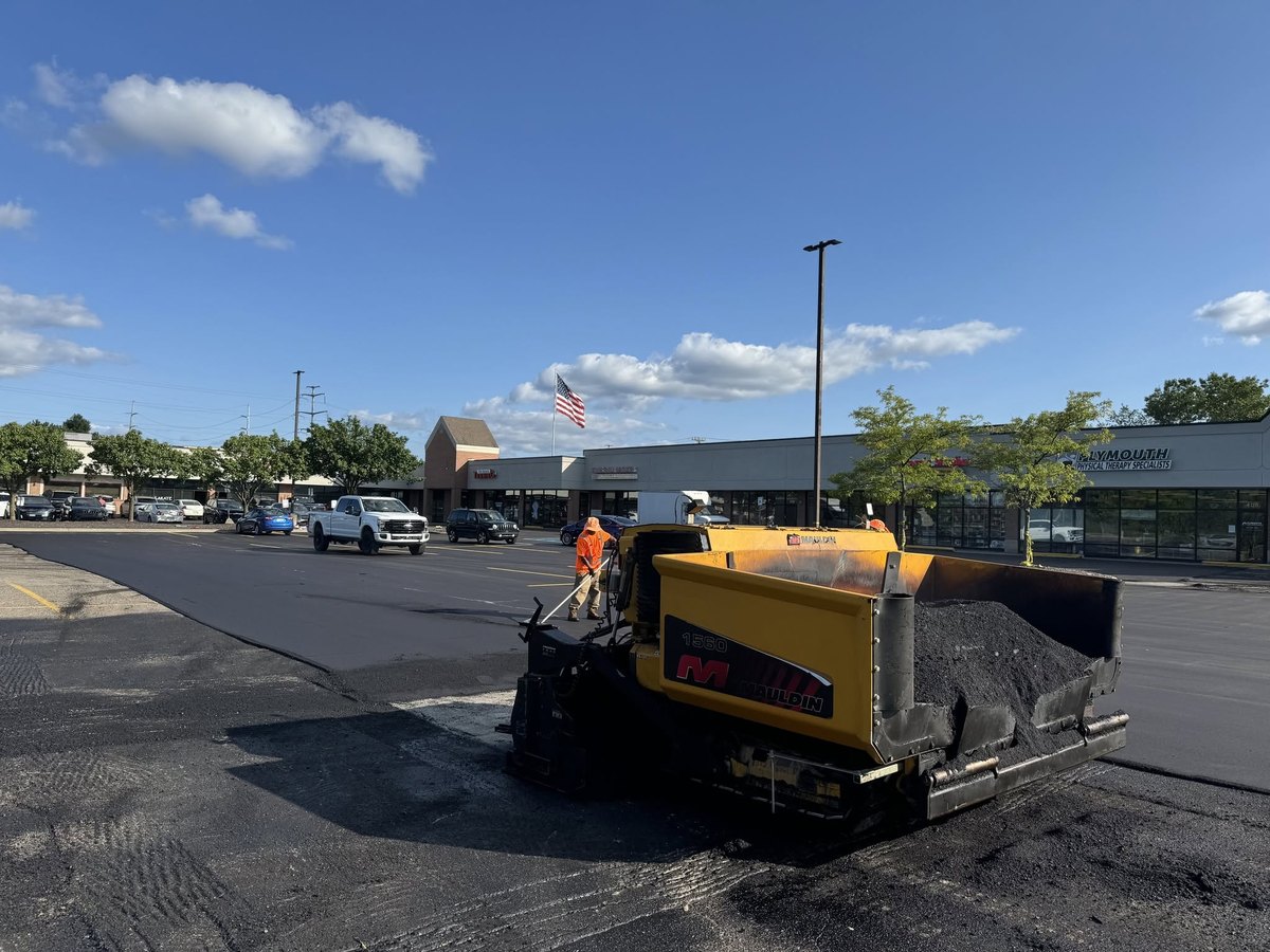 Asphalt paver laying hot mix on a parking lot